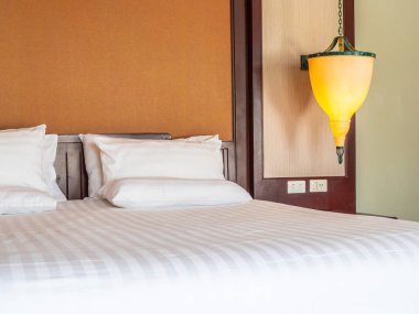 Otel yatak odasında ışık lamba dekorasyonu ile yatakta rahat yastık