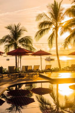 Güzel lüks otel ve tatil seyahat ve tatil için sandalye ve şemsiye ile açık yüzme havuzu