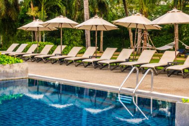 Güzel lüks otel ve tatil seyahat ve tatil için sandalye ve şemsiye ile açık yüzme havuzu