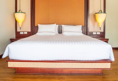 Otel yatak odasında ışık lamba dekorasyonu ile yatakta rahat yastık