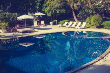 Güzel lüks otel ve tatil seyahat ve tatil için sandalye ve şemsiye ile açık yüzme havuzu