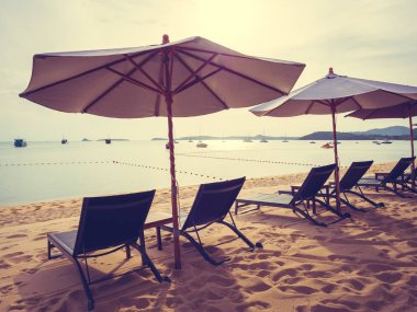 Şemsiye ve tropikal plaj deniz ve okyanus gündoğumu zaman seyahat ve tatil için sandalye