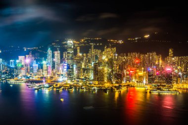 Hong Kong şehrinin dış şehir manzarası geceleri gökyüzüne yükseliyor.