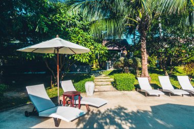 Güzel lüks otel ve tatil seyahat ve tatil için sandalye ve şemsiye ile açık yüzme havuzu