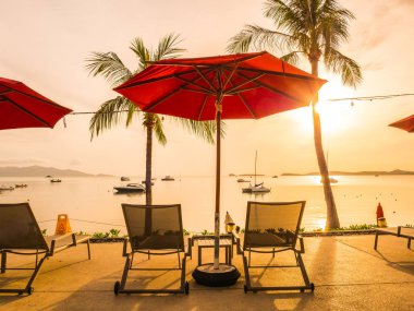 Şemsiye ve sandalye açık yüzme havuzunda otel ve gündoğumu zaman resort çevresinde