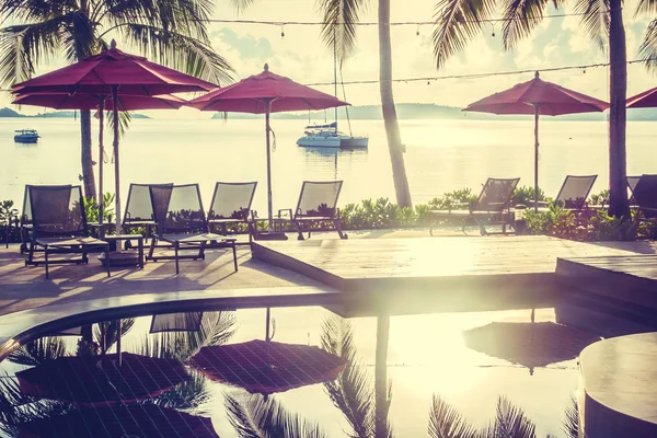 Güzel lüks otel ve tatil seyahat ve tatil için sandalye ve şemsiye ile açık yüzme havuzu