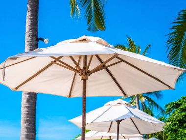 Hindistan cevizi hurma ağacı ile deniz okyanus seyahat ve tatil için mavi gökyüzü arka plan üzerinde Beyaz şemsiye