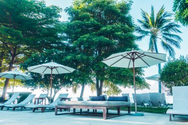 Güzel lüks otel ve tatil seyahat ve tatil için sandalye ve şemsiye ile açık yüzme havuzu