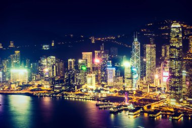 Hong Kong şehrinin dış şehir manzarası geceleri gökyüzüne yükseliyor.