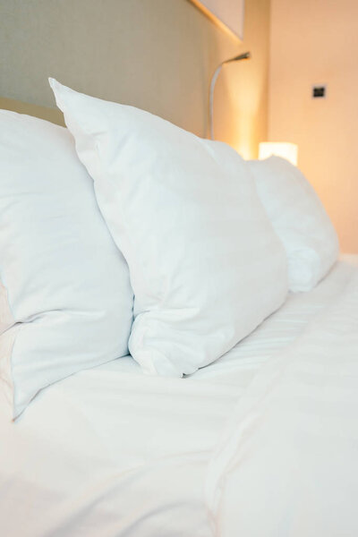 White pillow on bed decoration in hotel bedroom interior