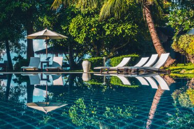 Güzel lüks otel ve tatil seyahat ve tatil için sandalye ve şemsiye ile açık yüzme havuzu