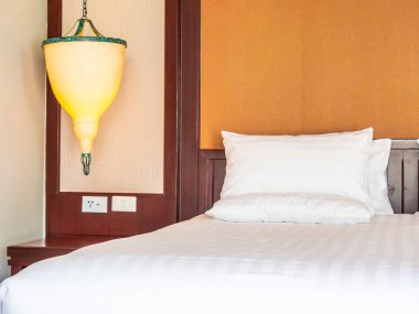 Otel yatak odasında ışık lamba dekorasyonu ile yatakta rahat yastık