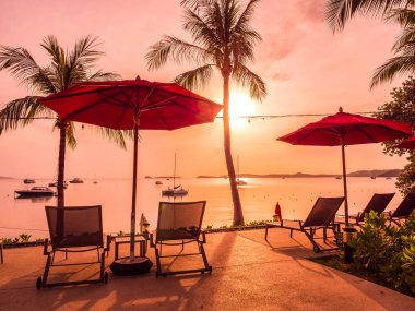 Şemsiye ve sandalye açık yüzme havuzunda otel ve gündoğumu zaman resort çevresinde