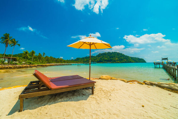 Umbrella and chair on the Beautiful tropical beach and sea with coconut palm tree in paradise island for travel and vacation