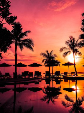 Şemsiye ve sandalye açık yüzme havuzunda otel ve gündoğumu zaman resort çevresinde