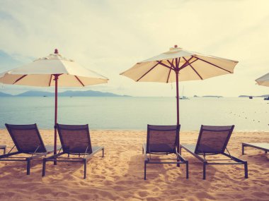 Şemsiye ve tropikal plaj deniz ve okyanus gündoğumu zaman seyahat ve tatil için sandalye