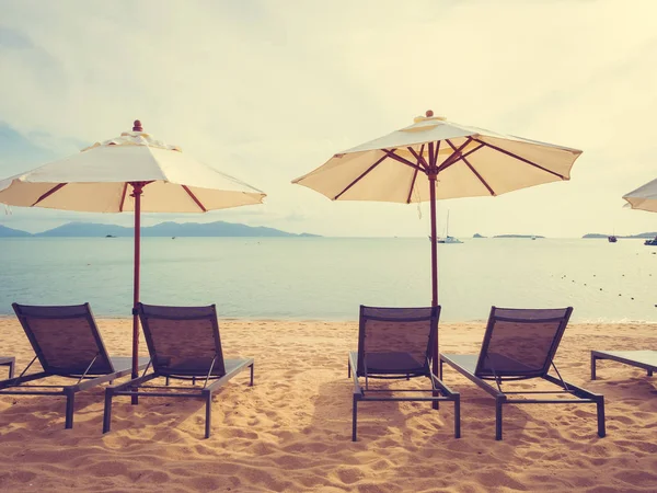 Şemsiye ve tropikal plaj deniz ve okyanus gündoğumu zaman seyahat ve tatil için sandalye