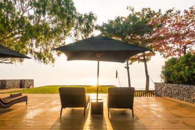 Şemsiye ve sandalye neary plaj ve gündoğumu zaman - tatil kavramı