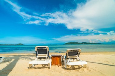 Güzel tropikal plaj ve Hindistan cevizi hurma ağacı ve Cennet Adası sandalyede denize sıfır