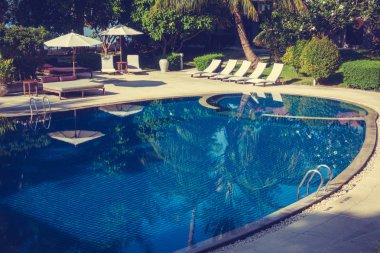 Güzel lüks otel ve tatil seyahat ve tatil için sandalye ve şemsiye ile açık yüzme havuzu