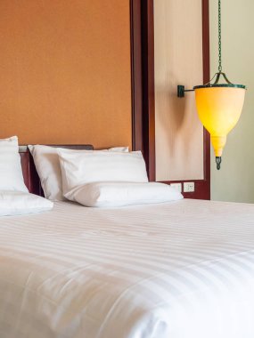 Otel yatak odasında ışık lamba dekorasyonu ile yatakta rahat yastık