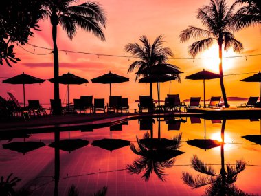Şemsiye ve sandalye açık yüzme havuzunda otel ve gündoğumu zaman resort çevresinde