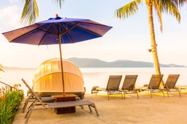 Şemsiye ve lüks otel ve gündoğumu zaman seyahat ve tatil için Resort'ta yüzme havuzu etrafında sandalye ile güzel açık görünüm