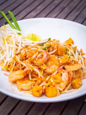 Ahşap masa üzerinde beyaz tabak karides ile Pad Tay erişte