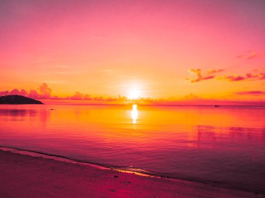 Güzel tropikal plaj ve okyanus yatay, bulut ve gökyüzü gündoğumu veya günbatımı zaman seyahat ve tatil için