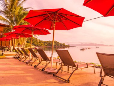 Şemsiye ve sandalye açık yüzme havuzunda otel ve gündoğumu zaman resort çevresinde