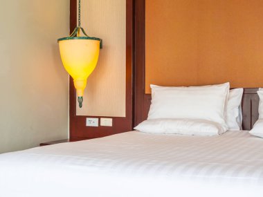 Otel yatak odasında ışık lamba dekorasyonu ile yatakta rahat yastık