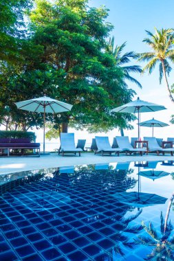 Güzel lüks otel ve tatil seyahat ve tatil için sandalye ve şemsiye ile açık yüzme havuzu