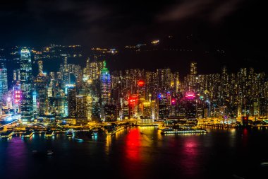 Hong Kong şehrinin dış şehir manzarası geceleri gökyüzüne yükseliyor.