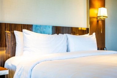 Güzel rahat beyaz yastık yatak yatak odası iç dekorasyonda ışık lamba ile