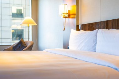 Güzel rahat beyaz yastık yatak yatak odası iç dekorasyonda ışık lamba ile