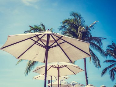 Hindistan cevizi hurma ağacı ile deniz okyanus seyahat ve tatil için mavi gökyüzü arka plan üzerinde Beyaz şemsiye