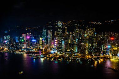 Hong Kong şehrinin dış şehir manzarası geceleri gökyüzüne yükseliyor.