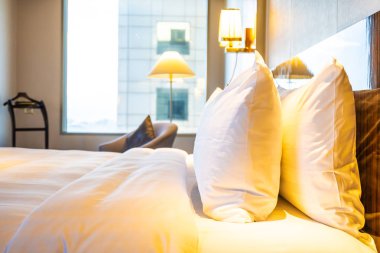 Güzel rahat beyaz yastık yatak yatak odası iç dekorasyonda ışık lamba ile