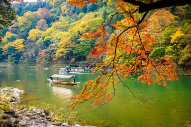 Akçaağaç ağaç yaprak ve sonbahar sezonu Kyoto Japonya göl etrafında tekne ile güzel Arashiyama Nehri