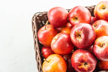 Bir sürü tablo üzerinde kahverengi sepet içinde kırmızı elma meyve
