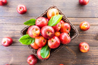 Bir sürü tablo üzerinde kahverengi sepet içinde kırmızı elma meyve