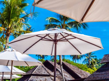 Hindistan cevizi hurma ağacı ile deniz okyanus seyahat ve tatil için mavi gökyüzü arka plan üzerinde Beyaz şemsiye