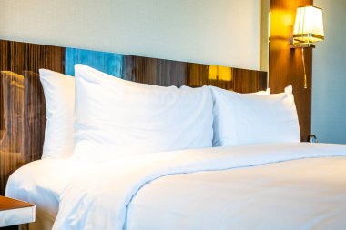 Güzel rahat beyaz yastık yatak yatak odası iç dekorasyonda ışık lamba ile