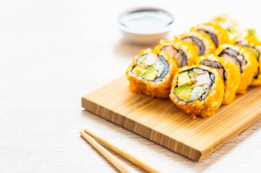 California maki sushi sos ve yemek çubukları - Japon yemekleri tarzı ahşap plaka üzerinde rulo