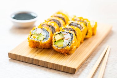 California maki sushi sos ve yemek çubukları - Japon yemekleri tarzı ahşap plaka üzerinde rulo