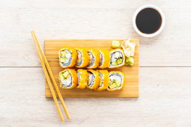 California maki sushi sos ve yemek çubukları - Japon yemekleri tarzı ahşap plaka üzerinde rulo