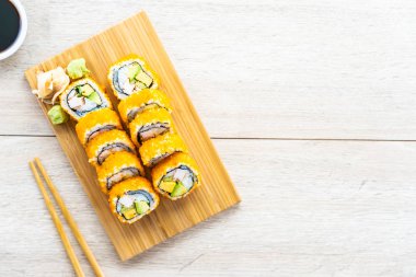 California maki sushi sos ve yemek çubukları - Japon yemekleri tarzı ahşap plaka üzerinde rulo