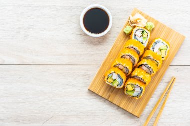 California maki sushi sos ve yemek çubukları - Japon yemekleri tarzı ahşap plaka üzerinde rulo