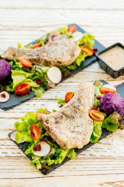 Izgara Barbekü domuz eti et biftek sebze, biber sosu ile siyah plaka üzerinde