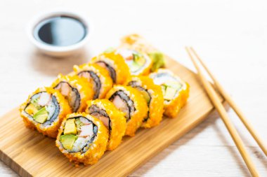 California maki sushi sos ve yemek çubukları - Japon yemekleri tarzı ahşap plaka üzerinde rulo